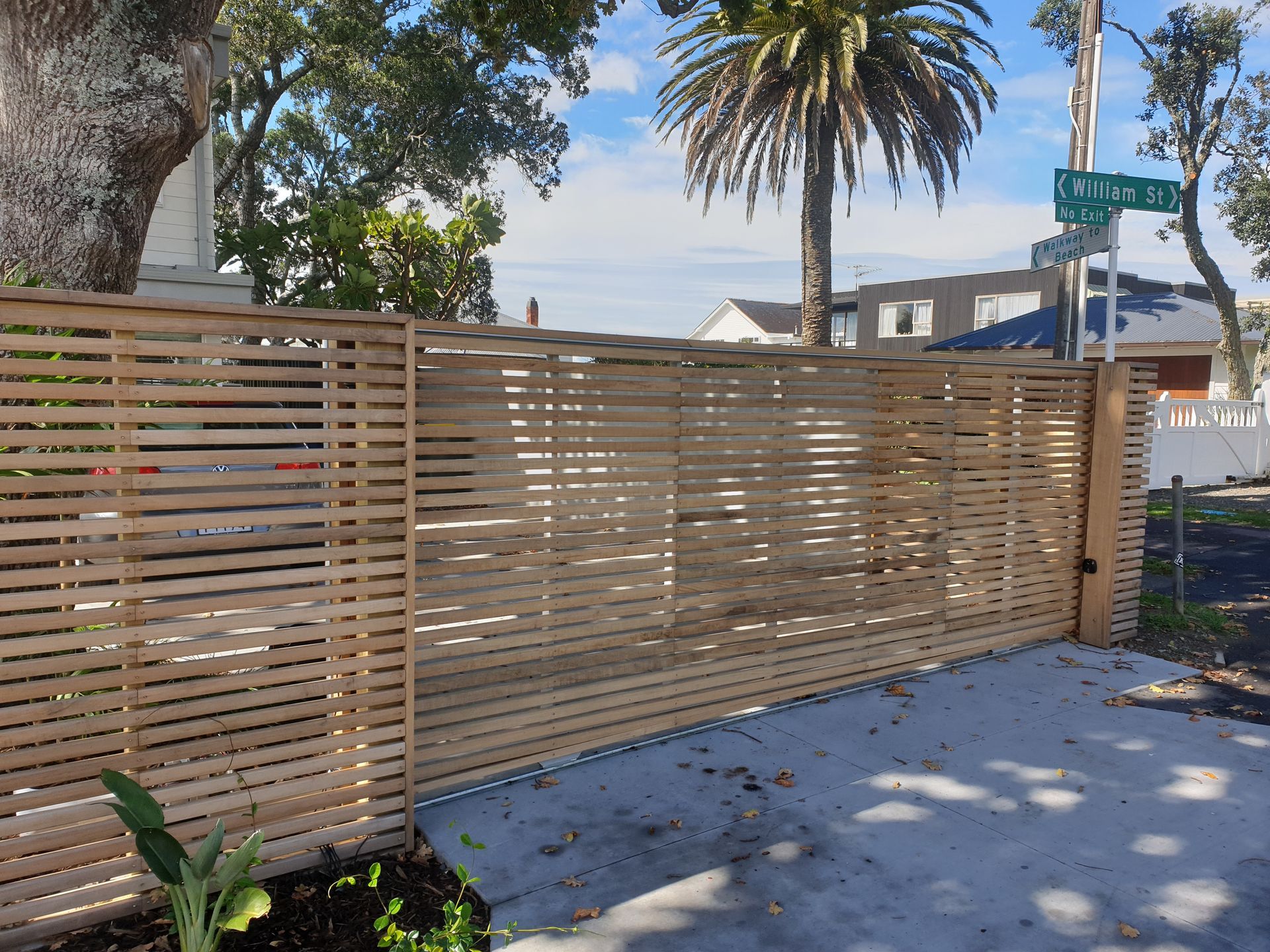 A wooden fence with a palm tree in the background