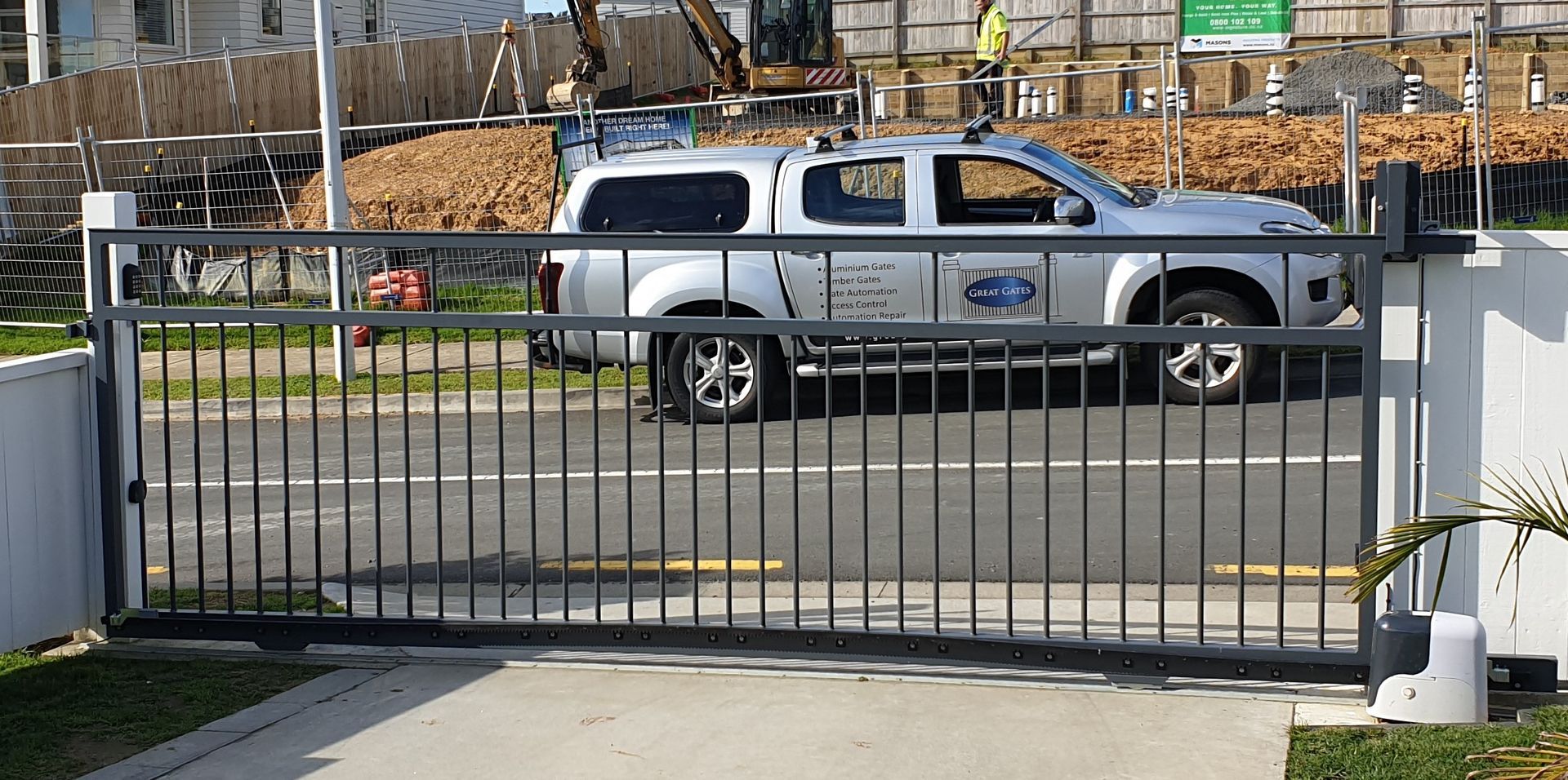 A truck is parked in front of a sliding gate.