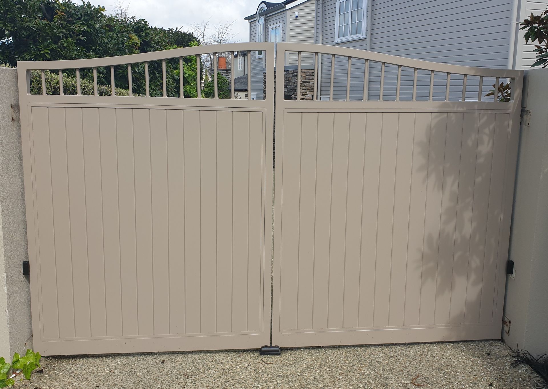 A white gate is open in front of a house