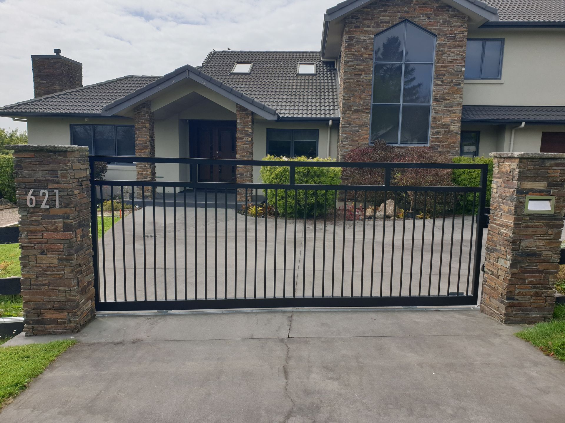 A large house with a sliding gate in front of it