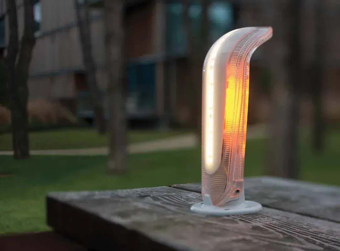 A lamp is sitting on top of a wooden table.