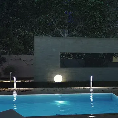 A large swimming pool is lit up at night.