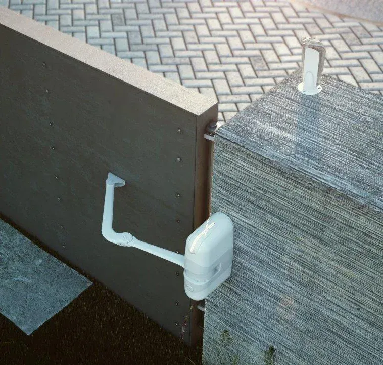 A white object is attached to a gray wall