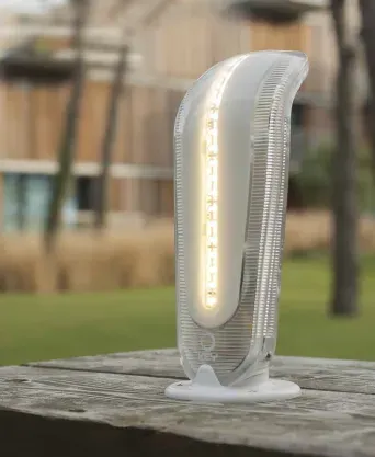 A white lamp is sitting on top of a wooden table.
