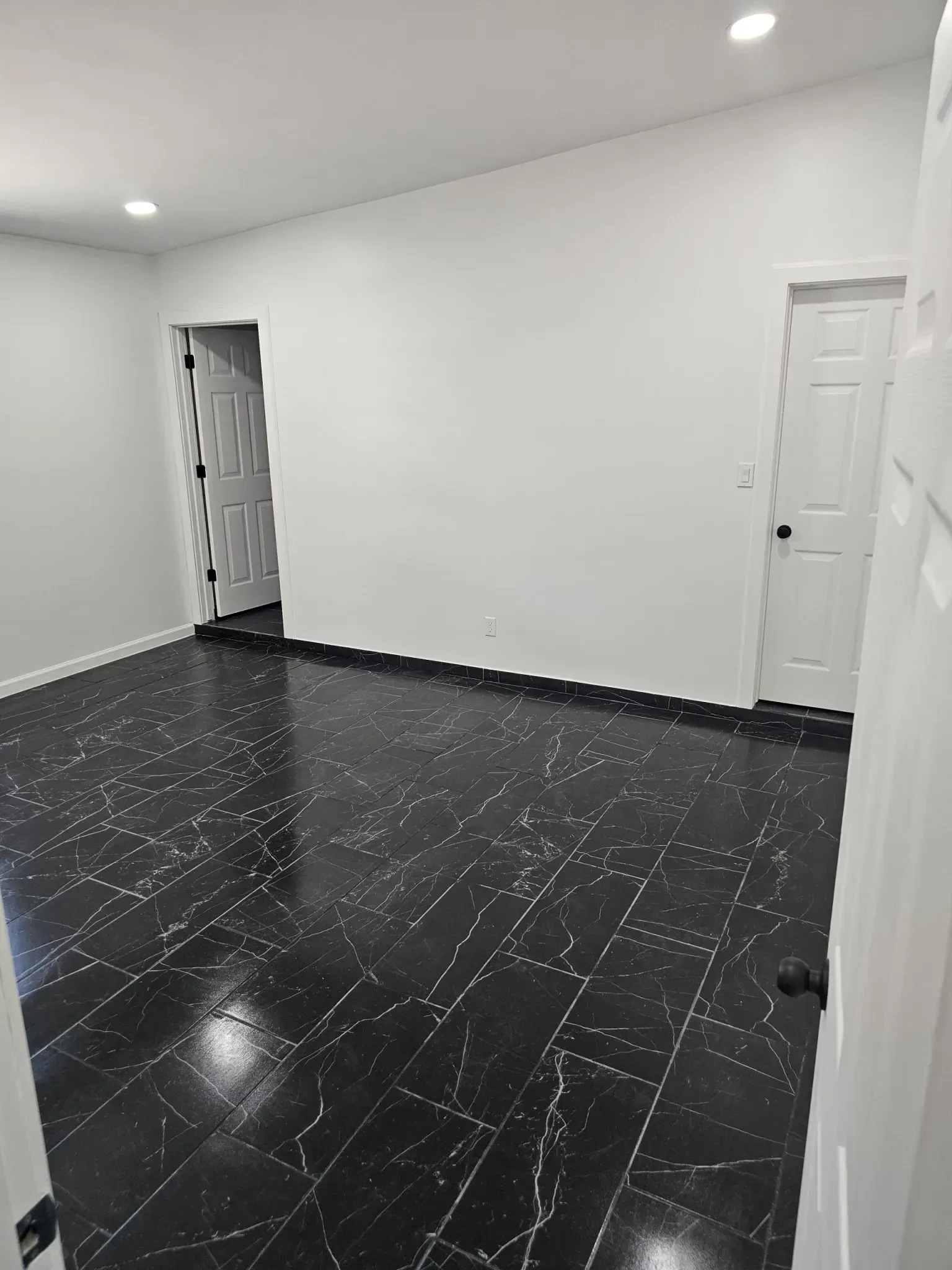 Woman in straw hat smiles, holding wine glass near a lake.