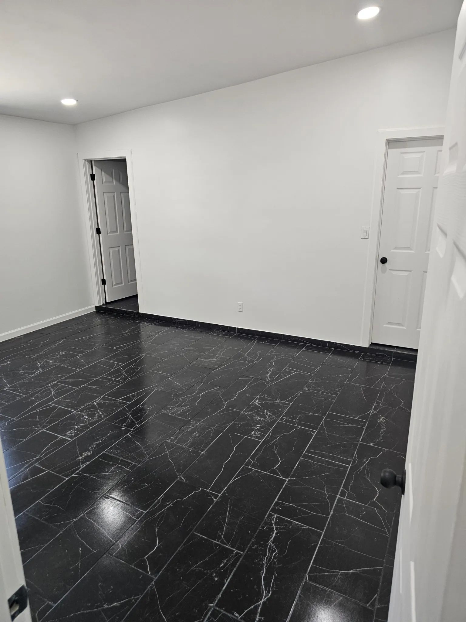 Woman in straw hat smiles, holding wine glass near a lake.