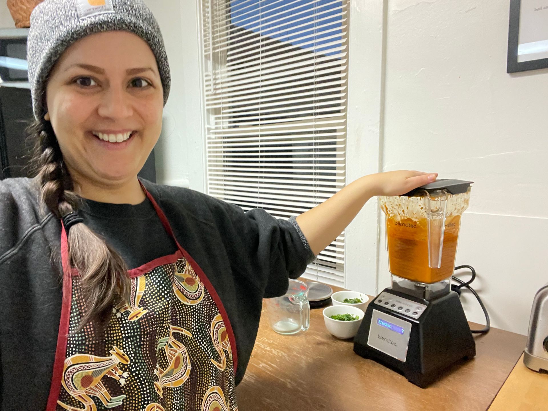 standing next to a blender 