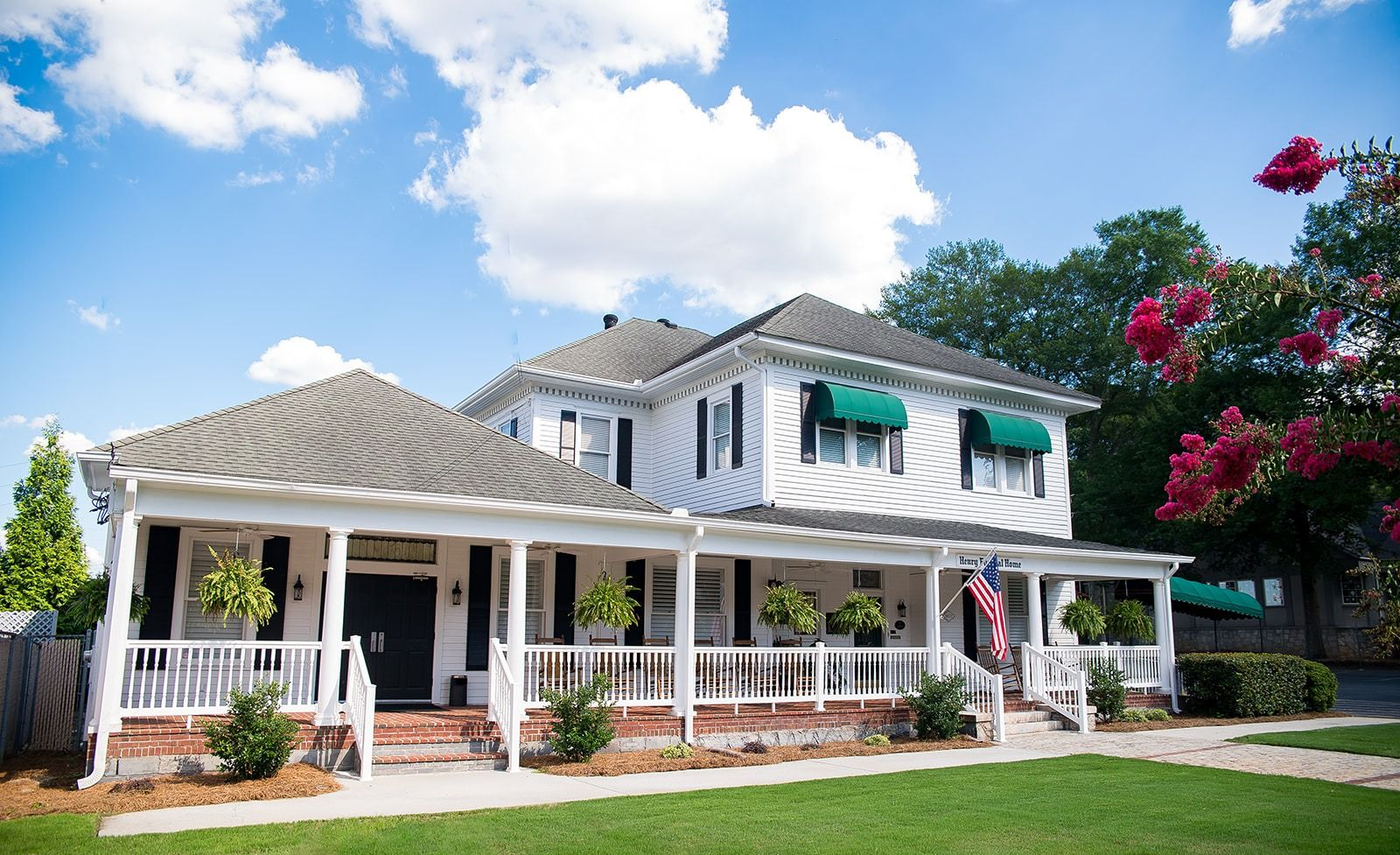 A large white building with a brown roof and a lot of windows.