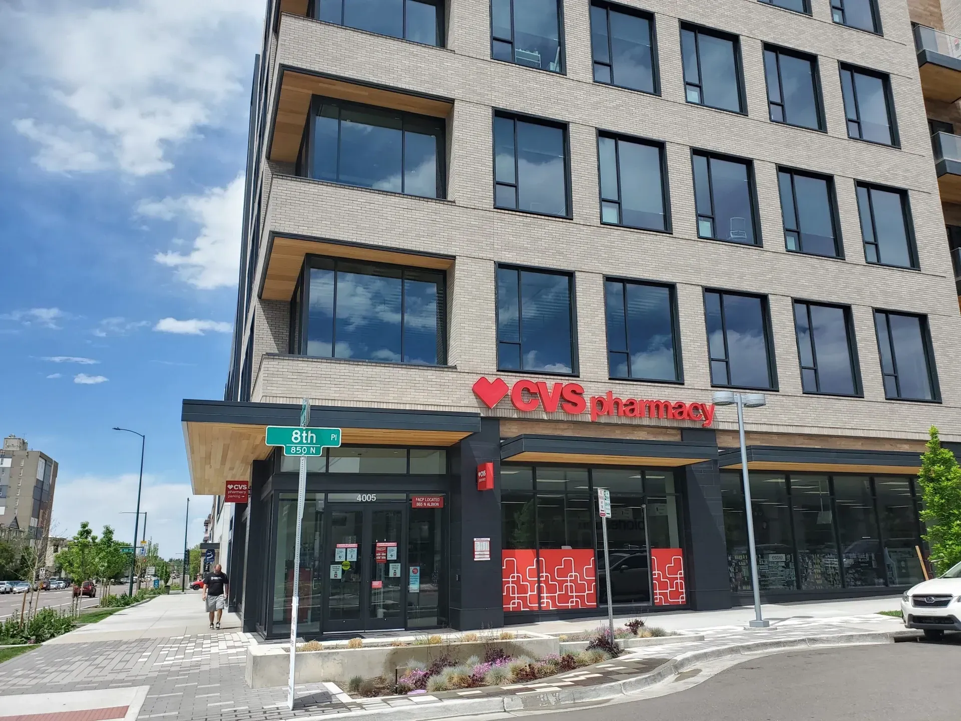 A large building with a lot of windows and a pharmacy on the side of it.