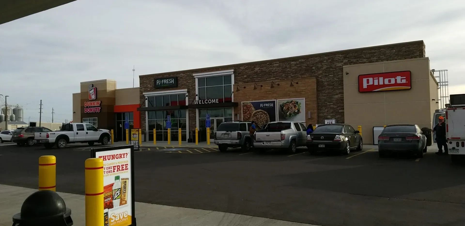 A gas station with cars parked in front of it.