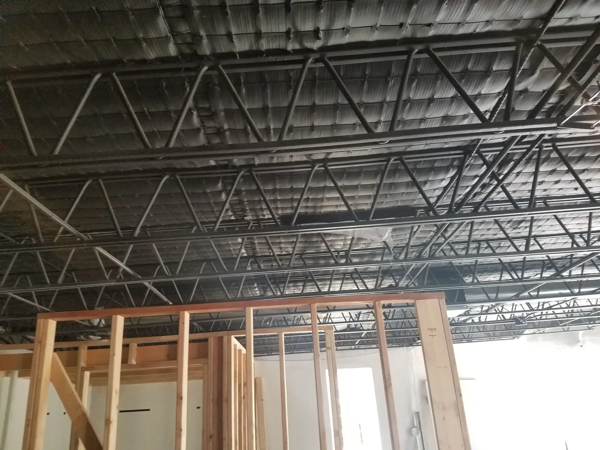 A building under construction with a metal roof and wooden frames.