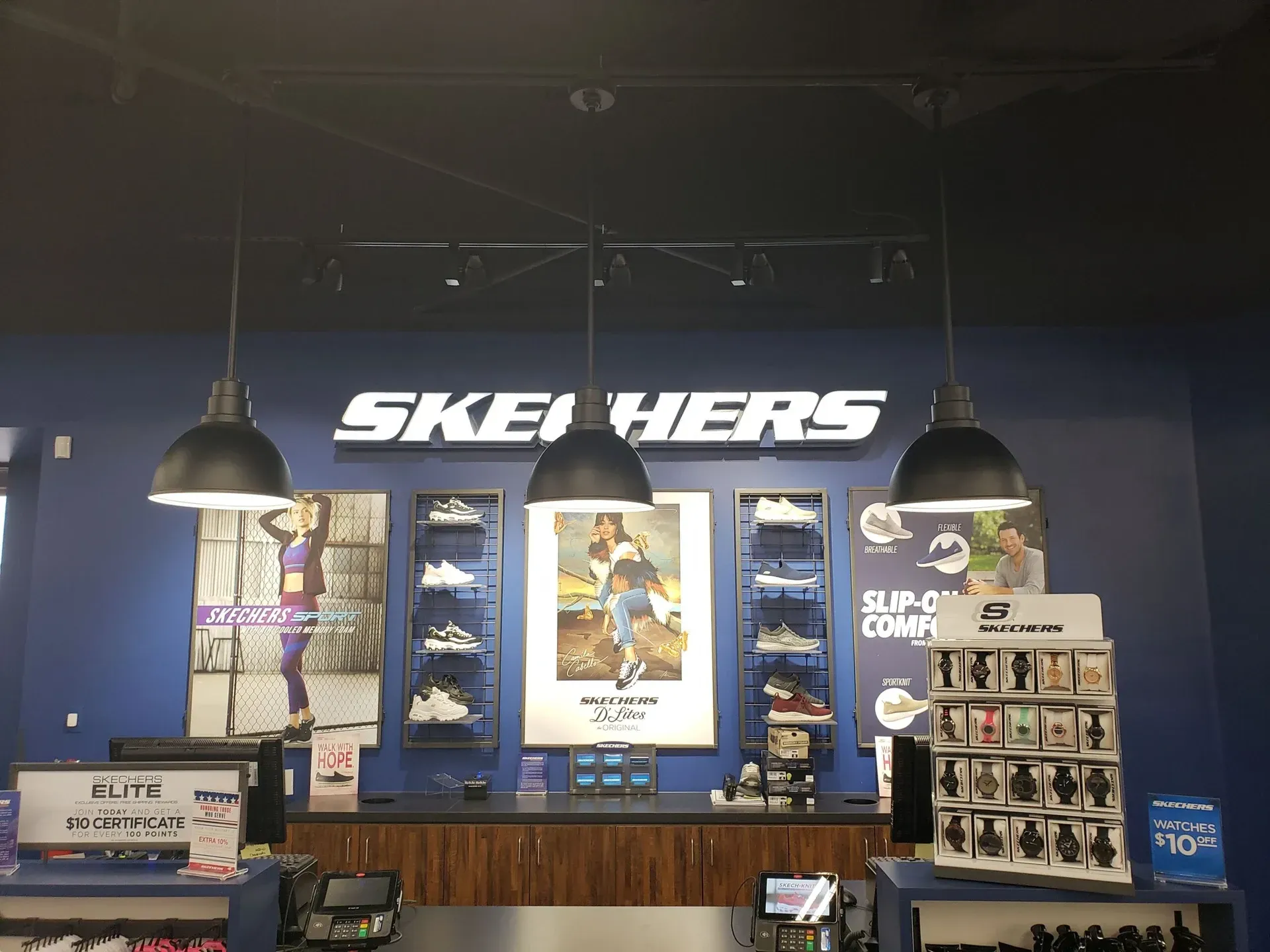 A skechers store with a sign on the wall above the counter