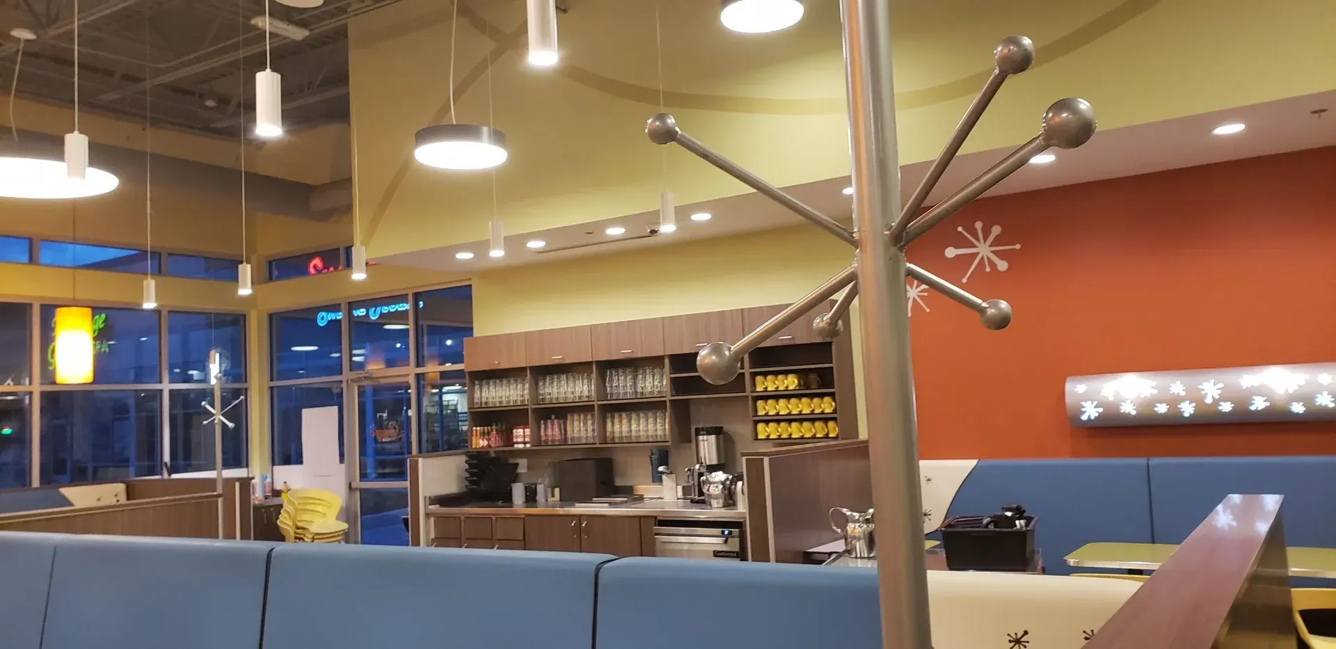 A restaurant with a blue couch and a red wall