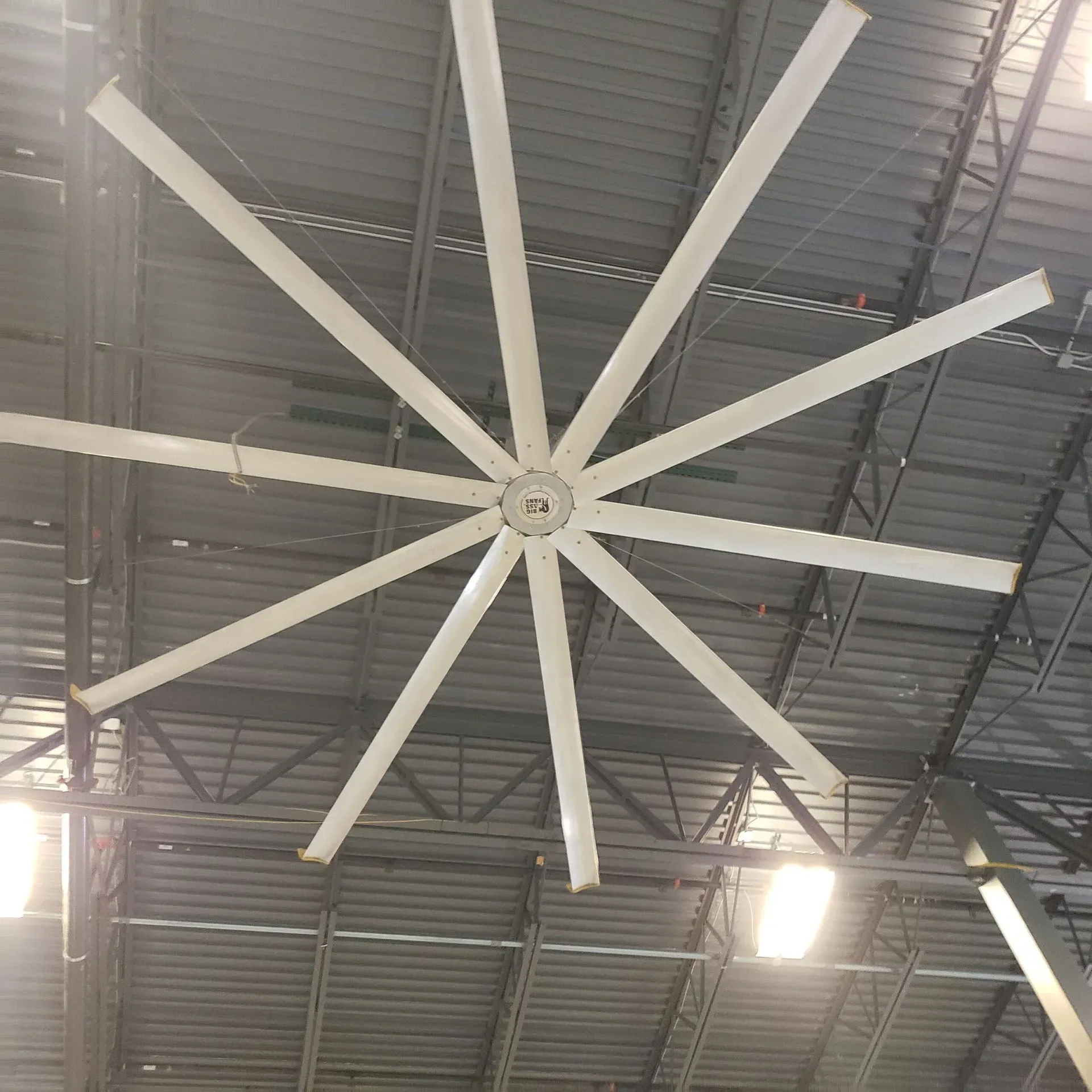A large ceiling fan is hanging from the ceiling of a building