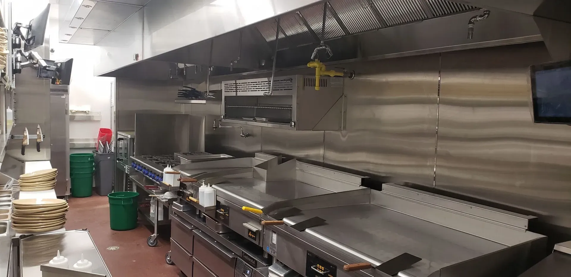 A large kitchen with a lot of stainless steel appliances.