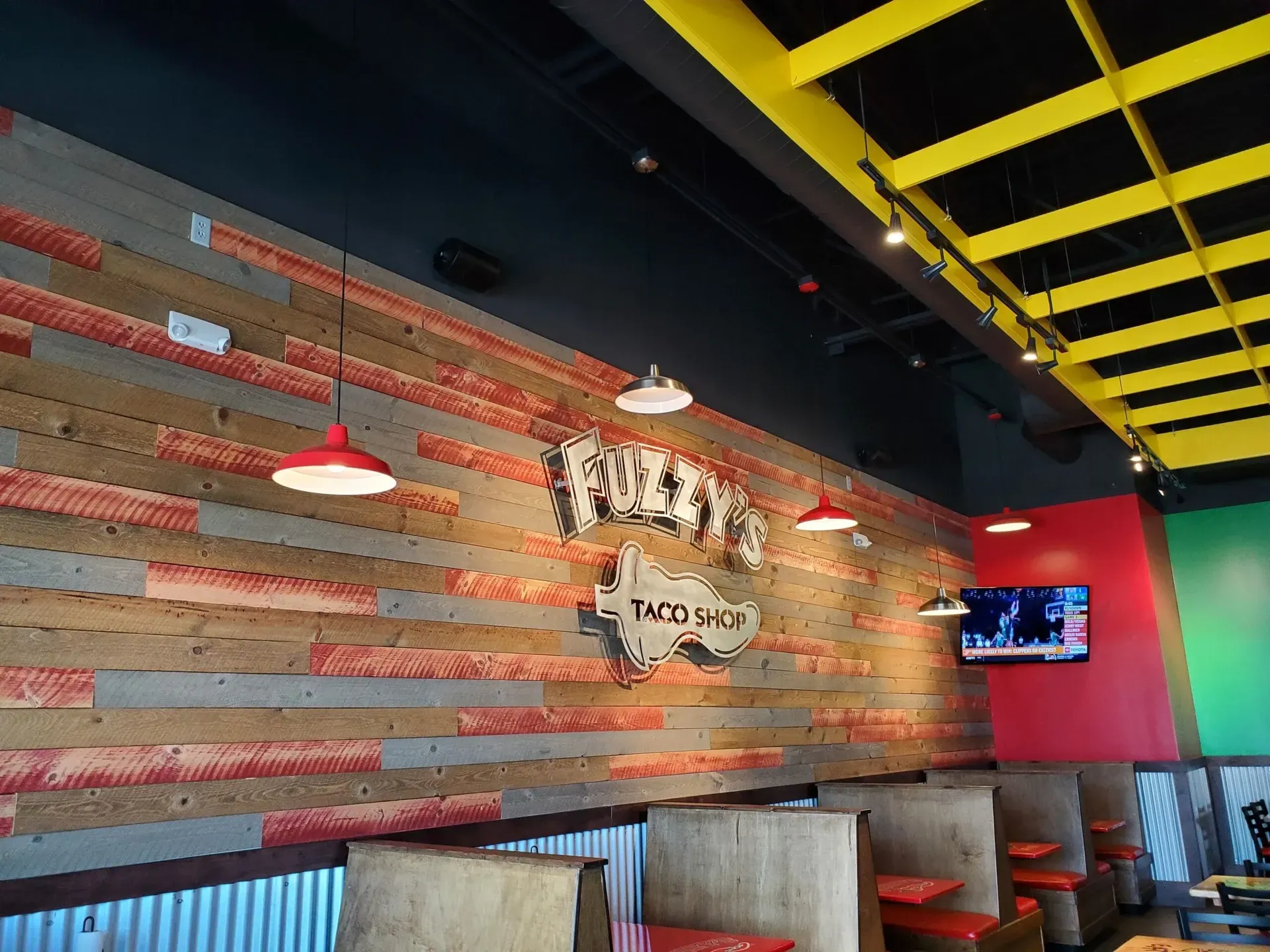 A restaurant with a wooden wall and tables and chairs.