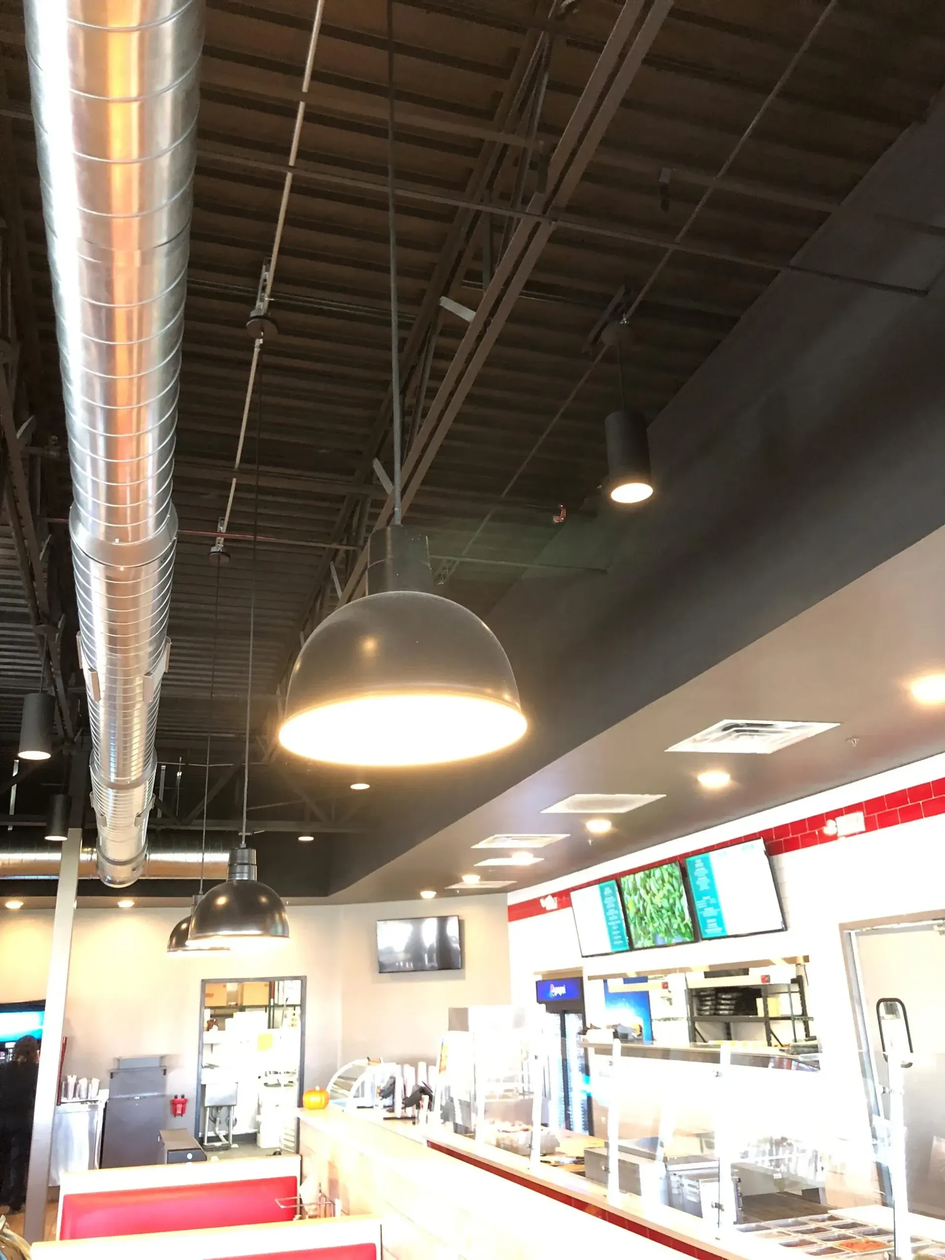 A restaurant with a ceiling that has a light hanging from it