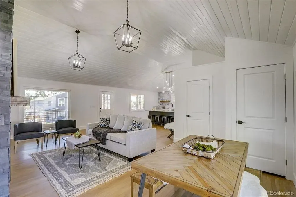 A living room with a white couch and a wooden table.
