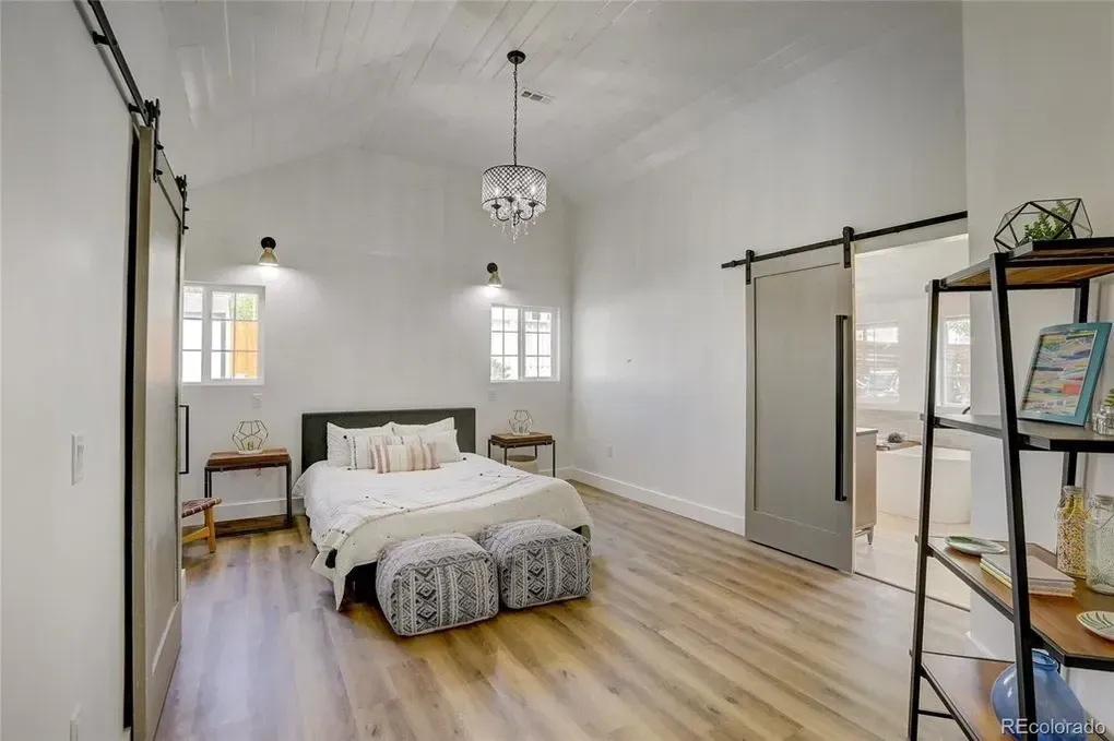 A bedroom with a sliding barn door and a bed.