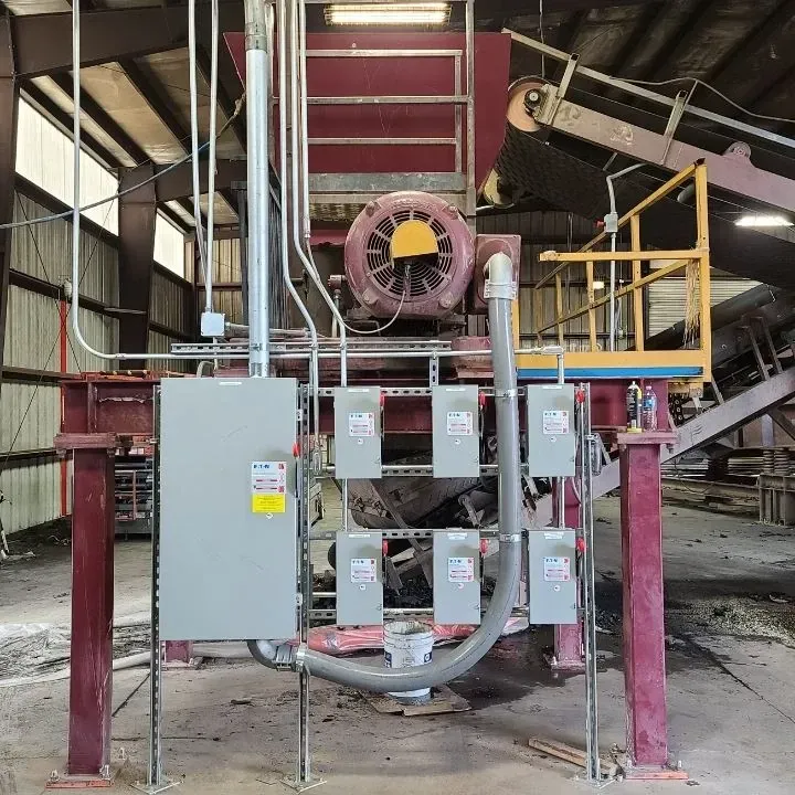 A machine is sitting in a warehouse with a lot of wires coming out of it.
