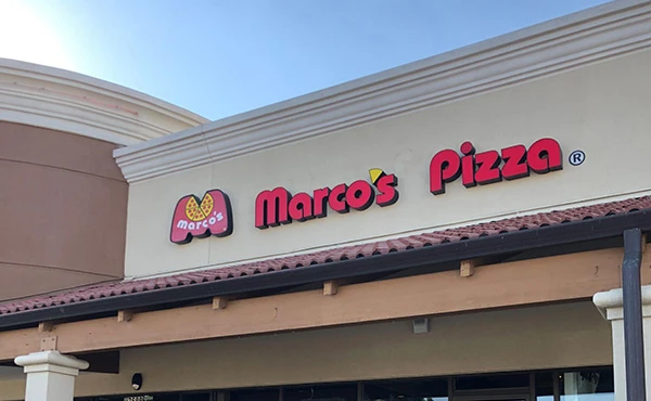 A restaurant called marco 's pizza is located in a shopping mall.