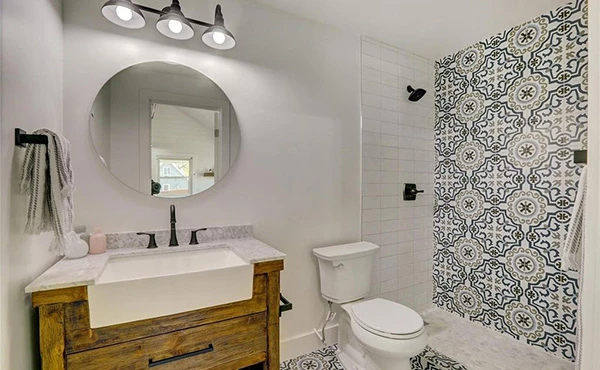 A bathroom with a toilet , sink and mirror.