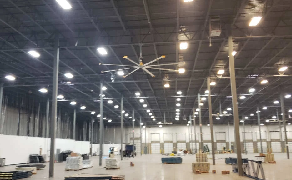 A large warehouse with a ceiling fan and lots of lights