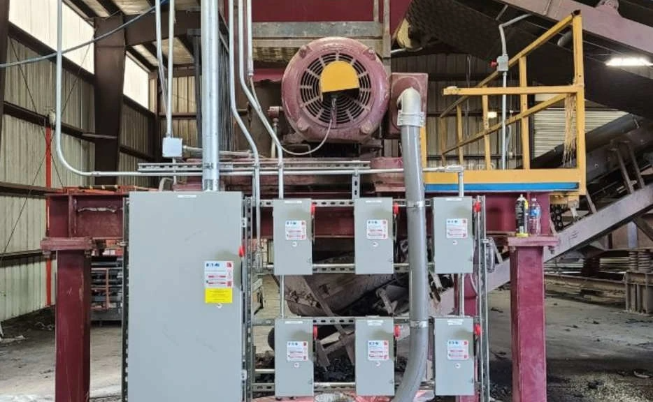 A large machine is sitting inside of a building with a lot of wires coming out of it.