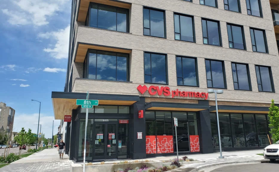 A cvs pharmacy is located on the corner of a city street.