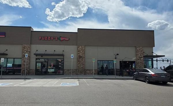 A large building with a car parked in front of it.