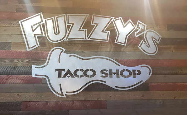 Fuzzy 's taco shop logo on a wooden table