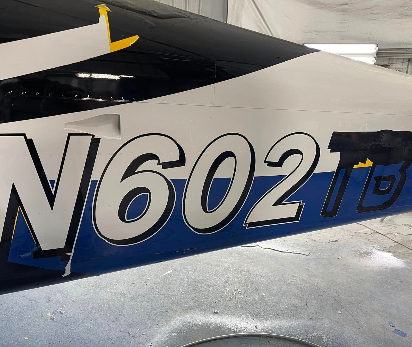 Aircraft tail with the registration number N602TD on a blue and white background.