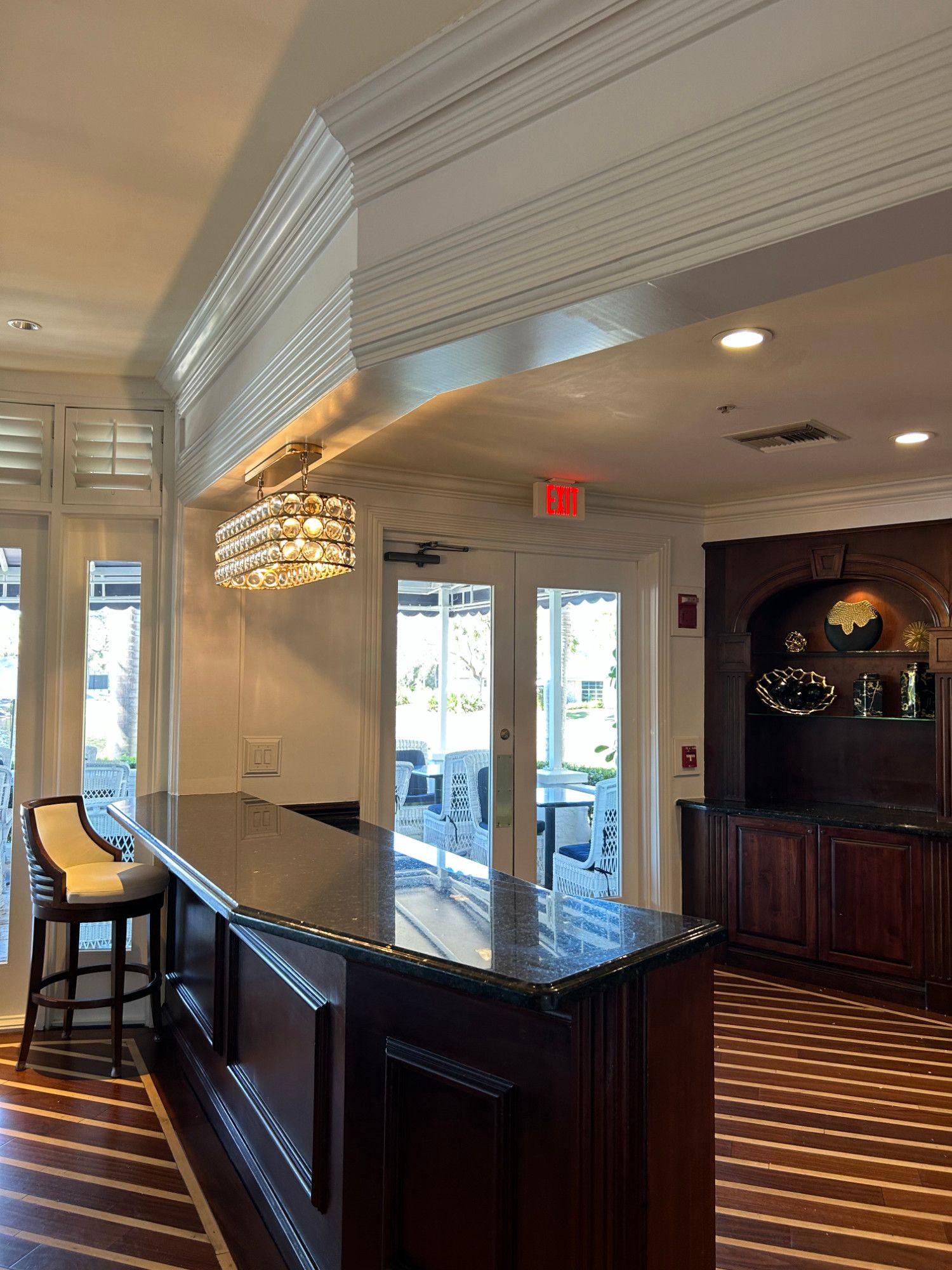 A hotel lobby with a bar and a red exit sign