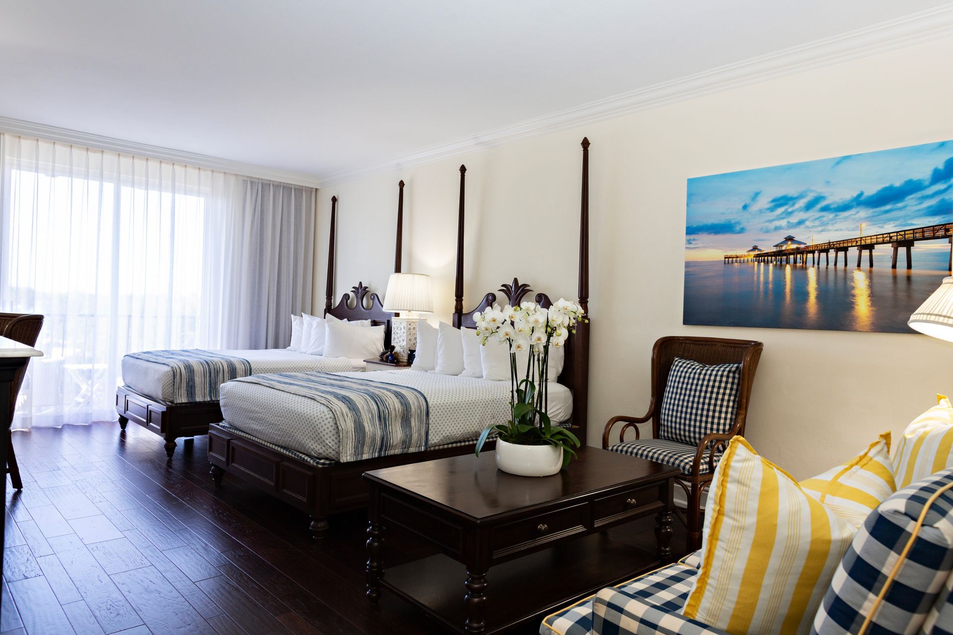 A hotel room with two beds and a painting on the wall