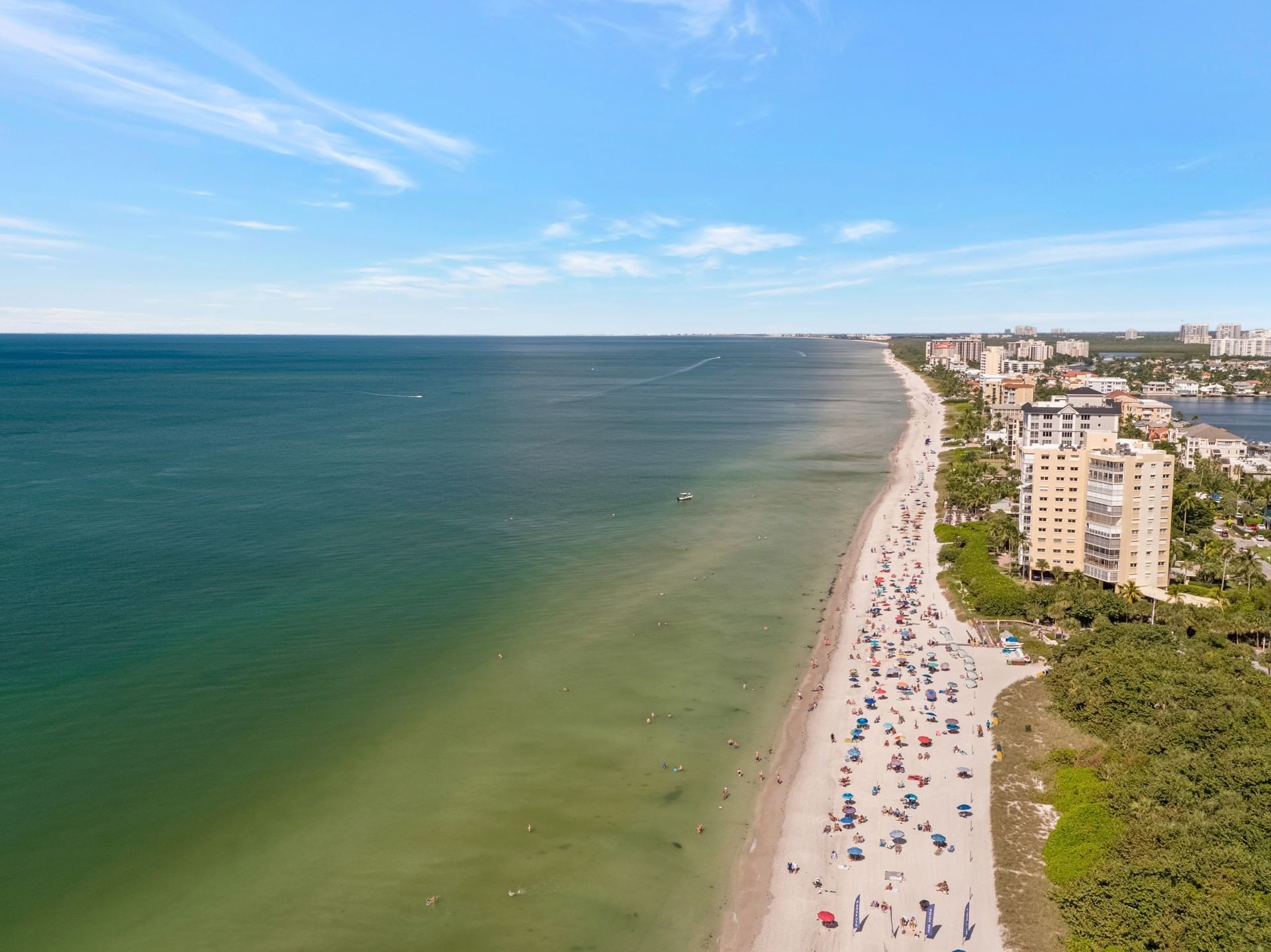 An aerial view of a beach with a lot of people on it.