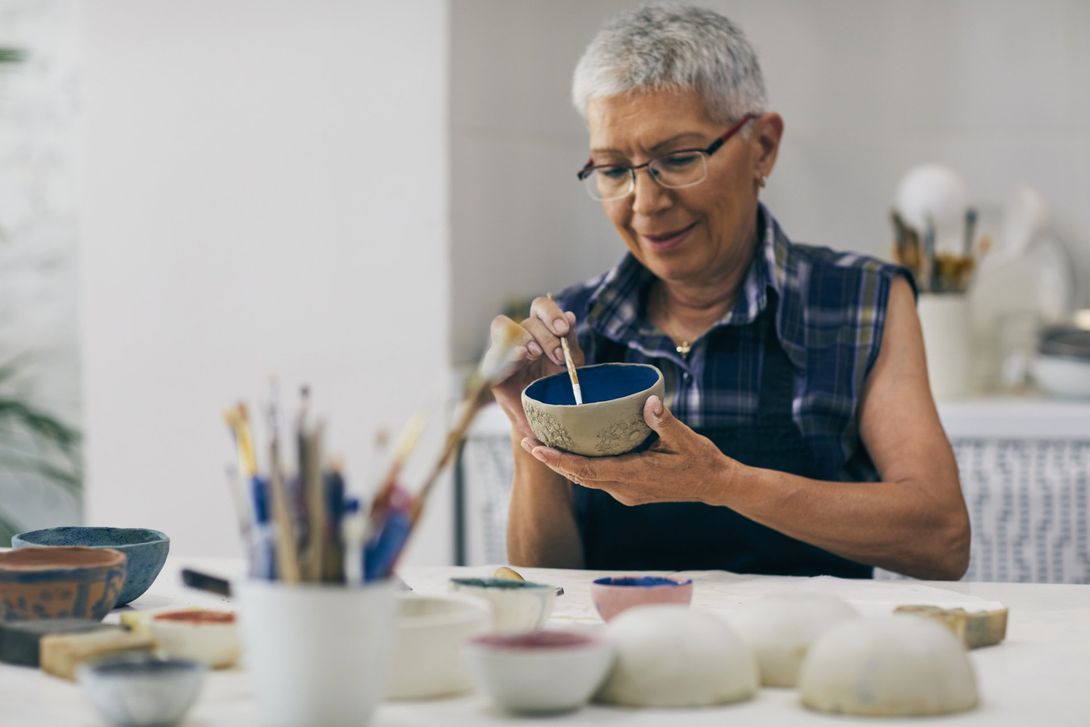 donna anziana che dipinge un vaso
