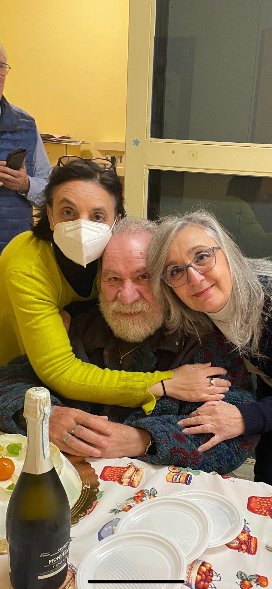 anziano che sorride con due assistenti