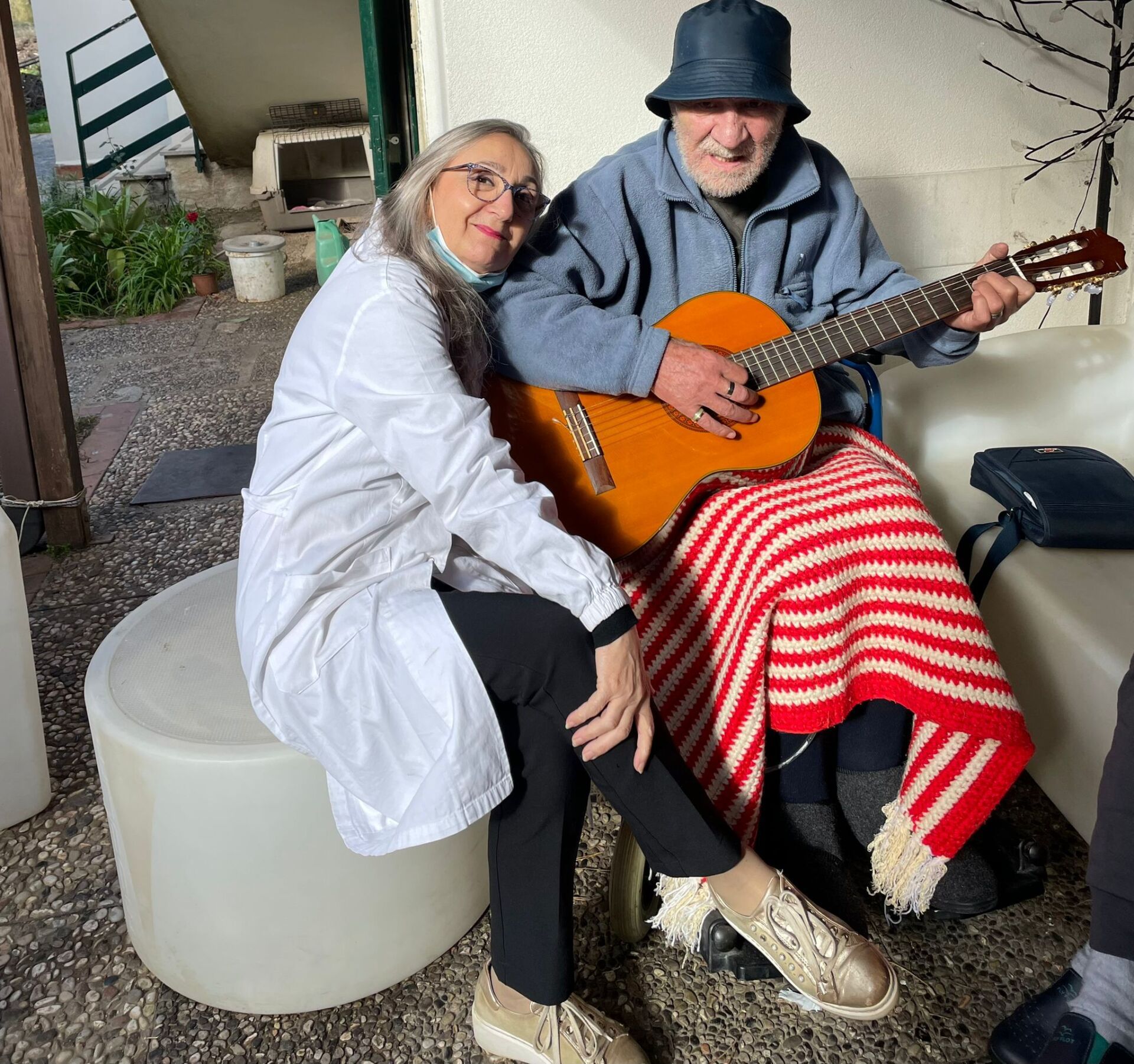 uomo anziano che suona la chitarra con assistente