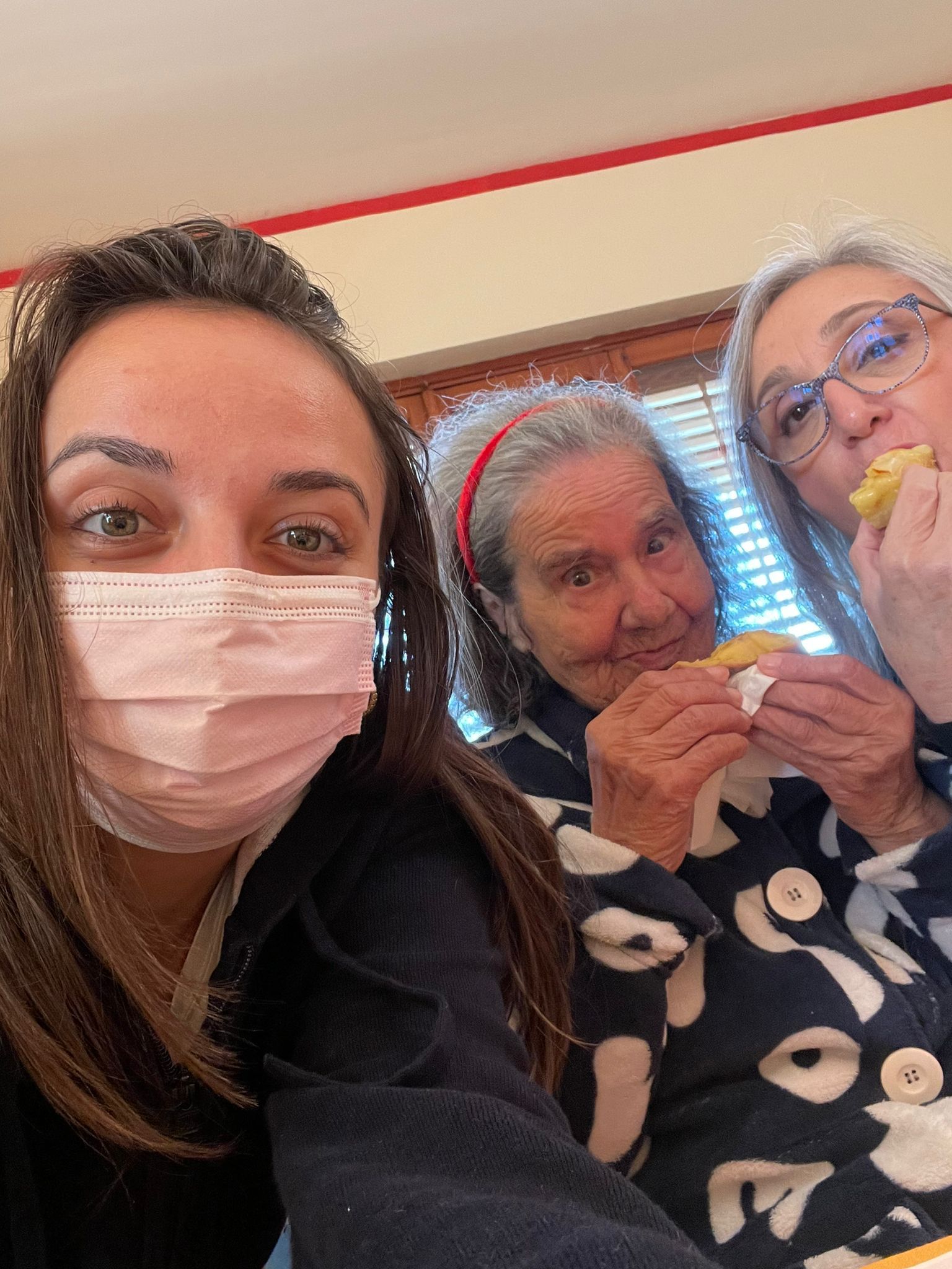 donne anziane che mangiano con assistente