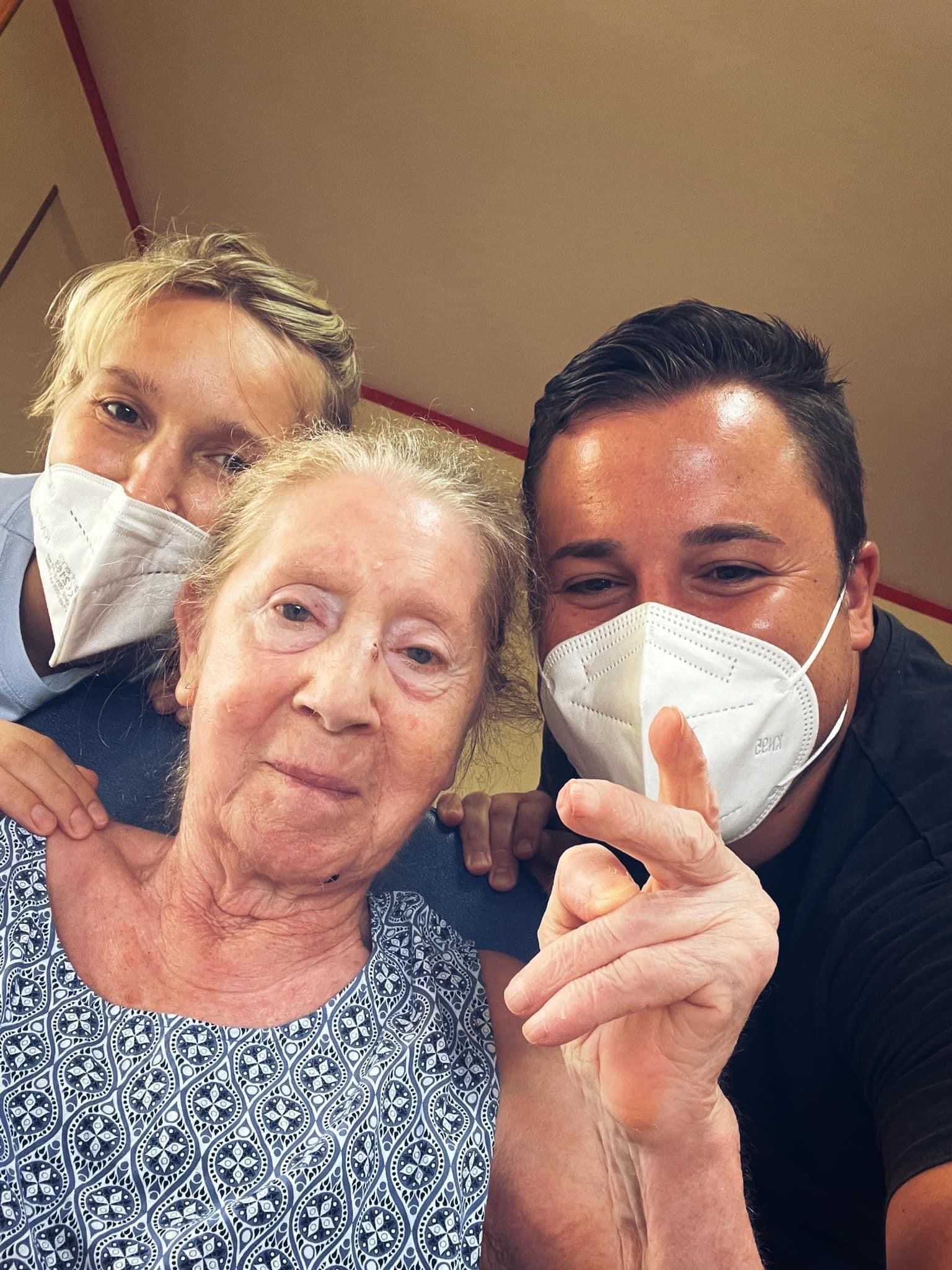 donna anziana con assistenti con mascherina