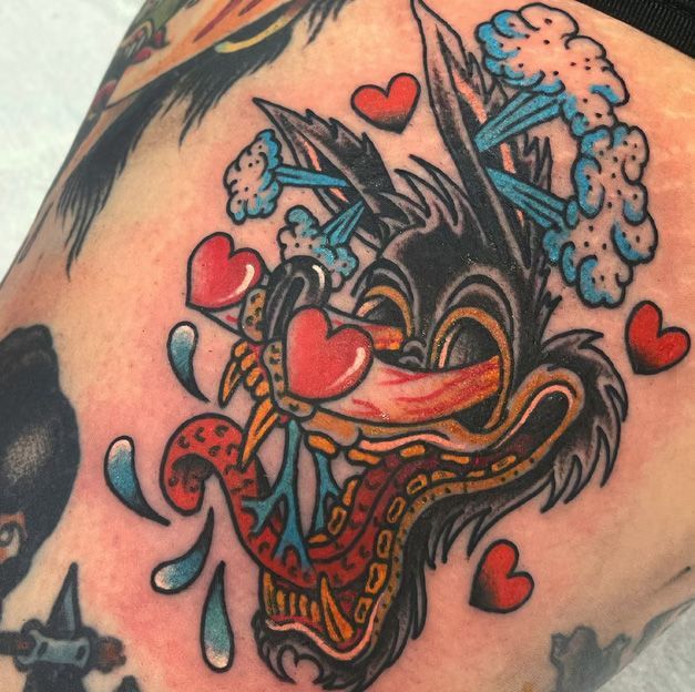 A tattoo of a wolf with hearts in its mouth