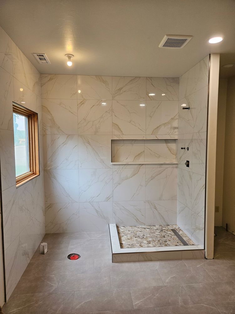 Newly tiled bathroom with shower, neutral colors, and a built-in shower niche.