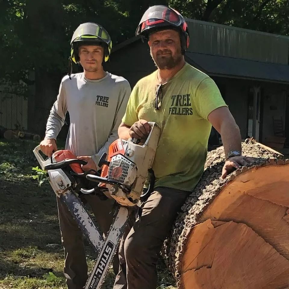 Two men are standing next to each other one is wearing a shirt that says tree rollers