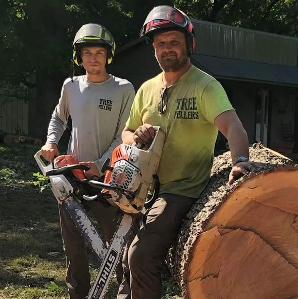 Two men are standing next to each other one is wearing a shirt that says tree rollers