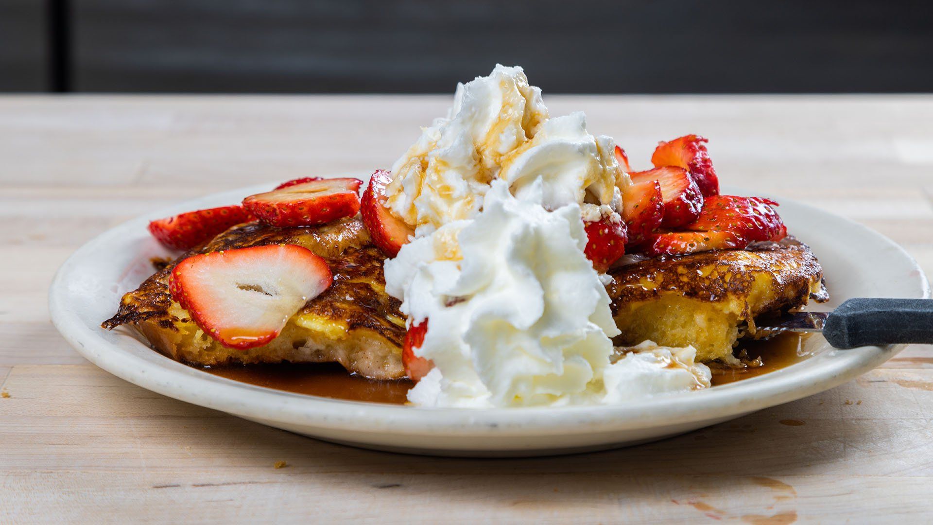 Cinnamon roll French toast with strawberries and scratch made whipped cream