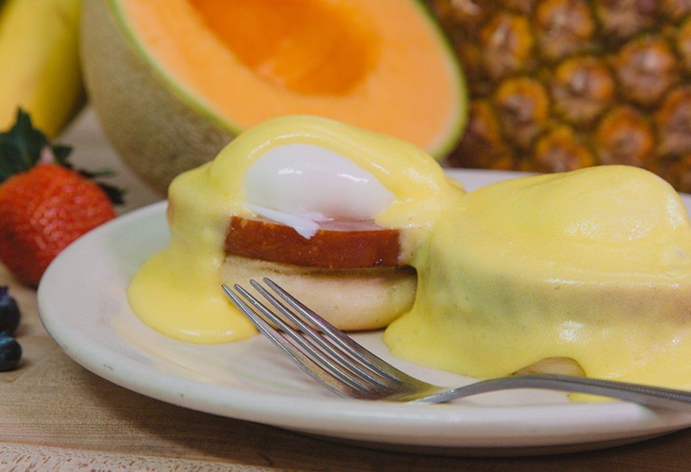 A close up of a plate of food with a fork on a table.