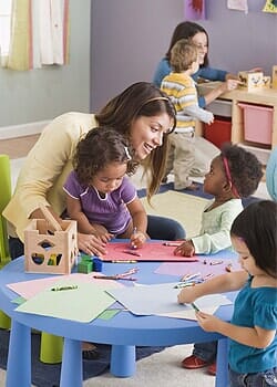A woman teaching a child at a kindergarten in Boulder, CO