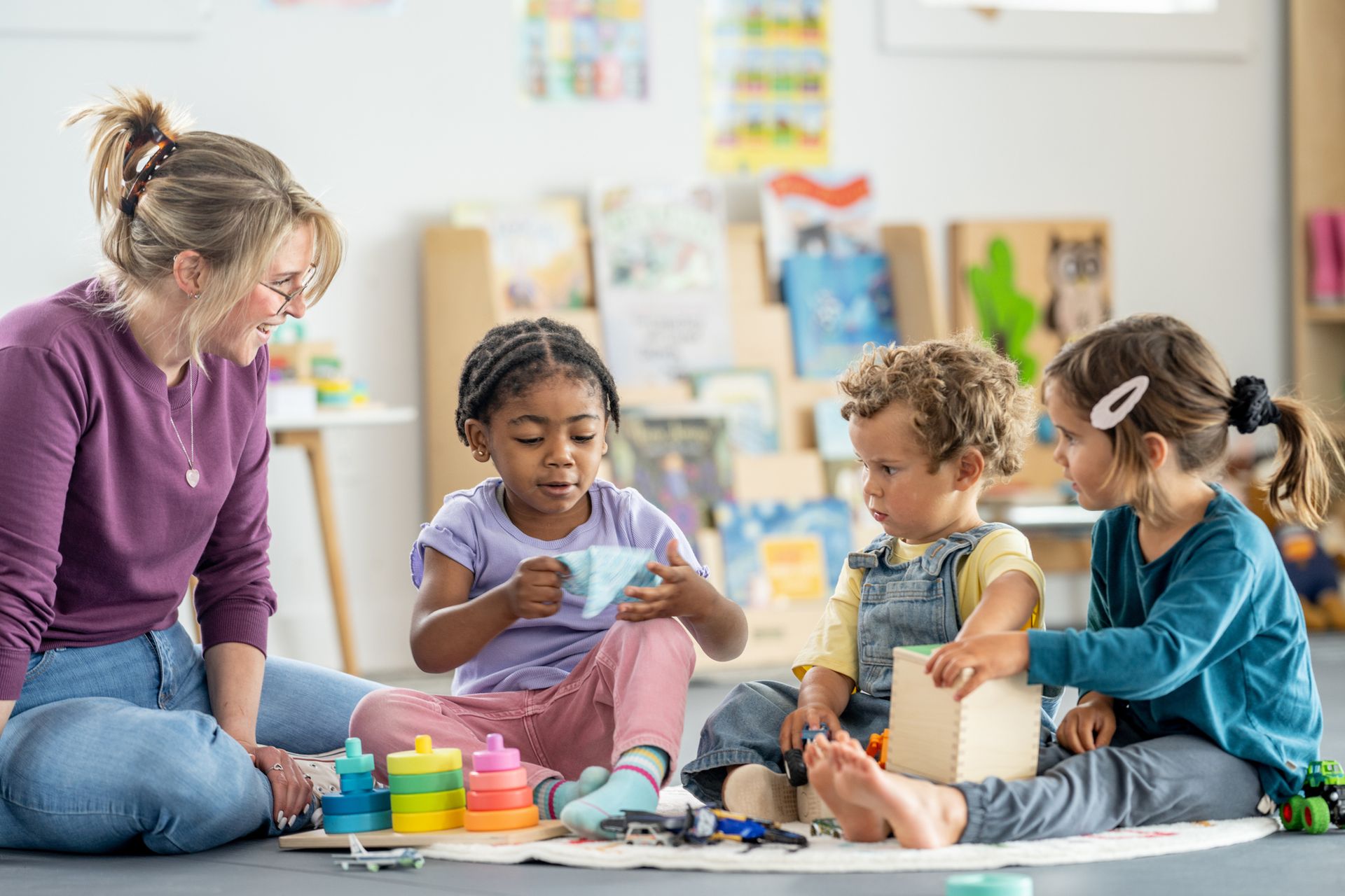Children interacting with a teacher and playing educational games.