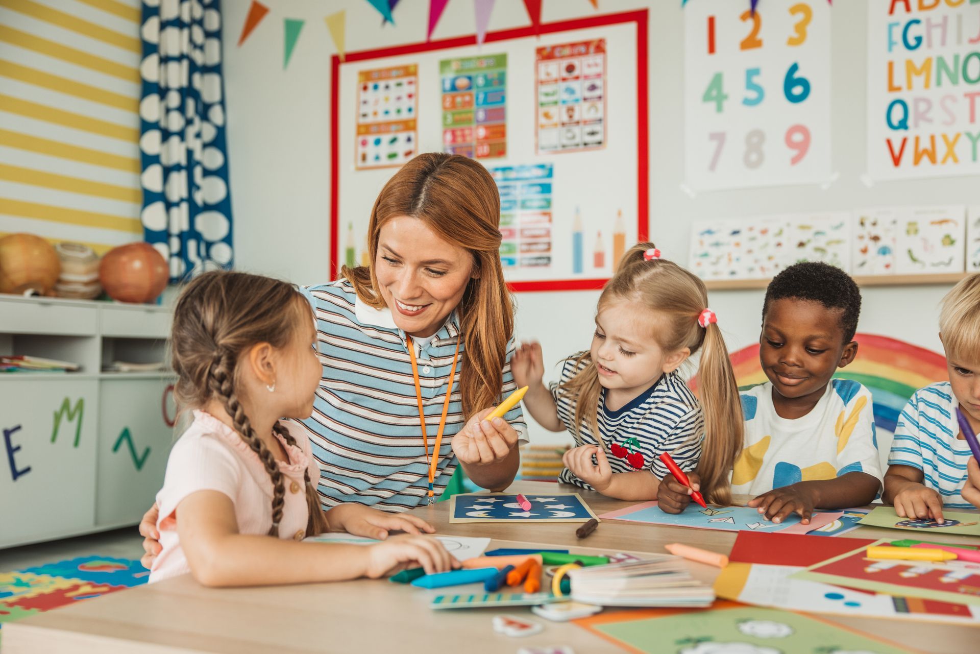 Teacher drawing with a group of children at kindergarten.