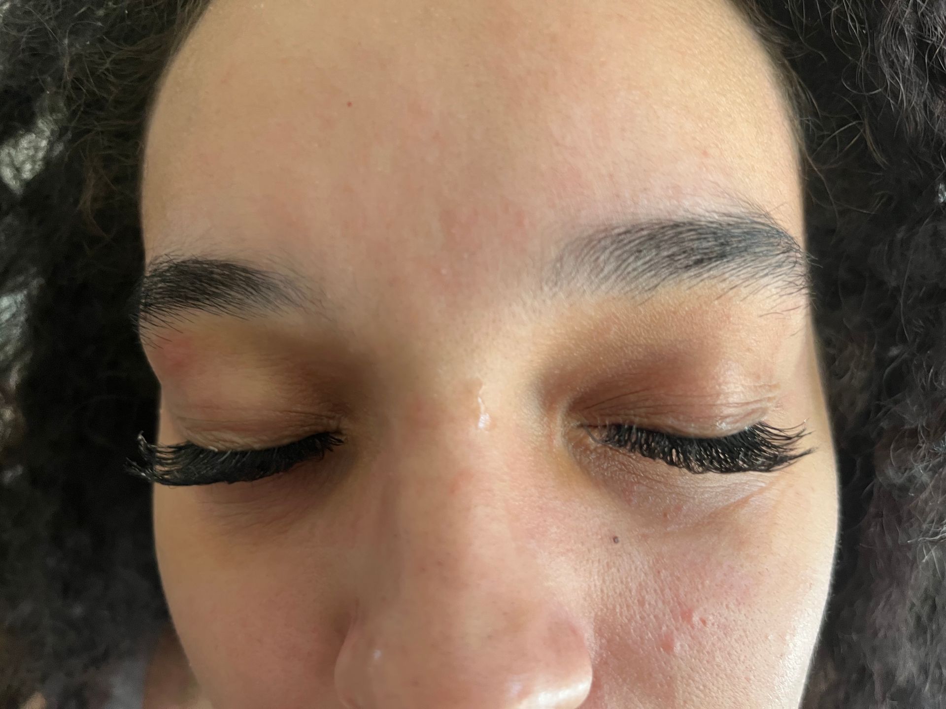 A close-up of a person's face with eyes closed.